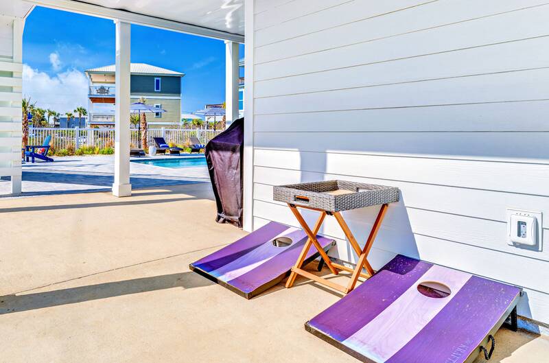 Cornhole boards on the shaded patio under the house