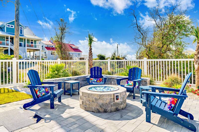 Fire pit with Adirondack chairs in the fenced yard