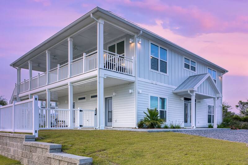 Side of the house with its two levels of porches at dusk