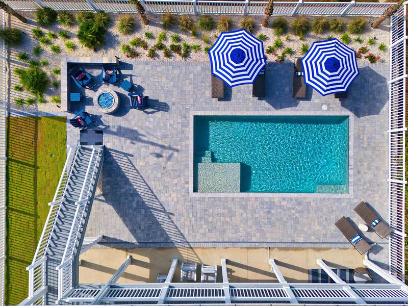 Pool deck from above, with umbrellas and the fire pit